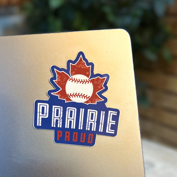 A die cut vinyl sticker with a maple leaf and baseball and the text 'Prairie Proud' on a laptop.