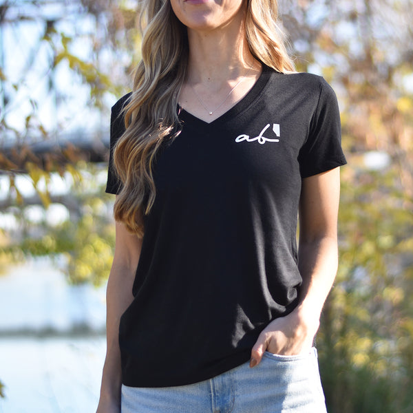 Woman wearing a black v-neck t-shirt that says 'ab' (Alberta) on the top left side.
