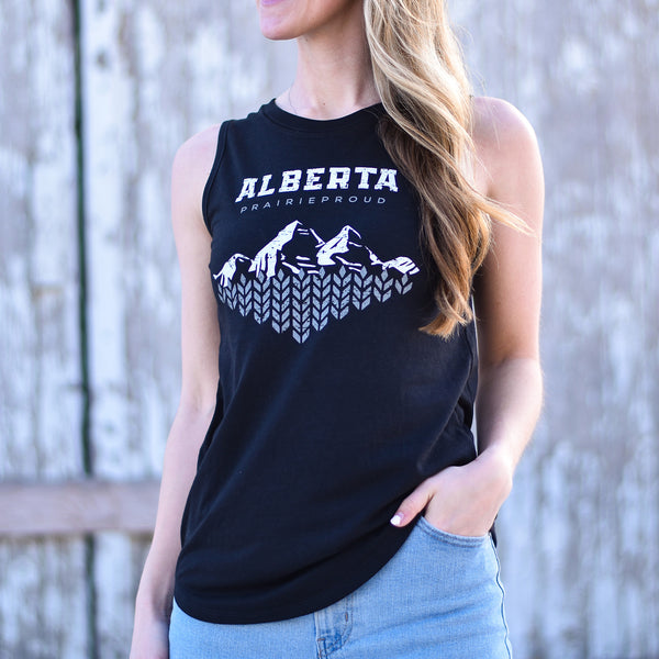 A woman wearing a black sleeveless tank top with 'Alberta' and 'Prairie Proud' with a mountain design printed on the front.