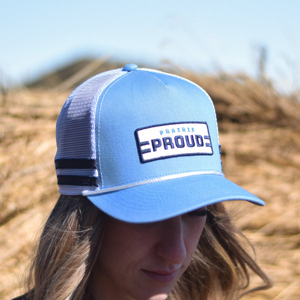 A person wearing a blue, navy, and white striped trucker hat with a text logo in the front.