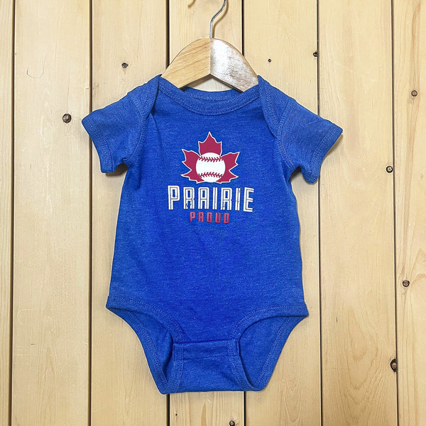 A blue baby onesie with short sleeves, hanging on a wooden hanger against a wooden backdrop. The onesie has a graphic print of a maple leaf with a baseball in the centre and text 'PRAIRIE PROUD'.