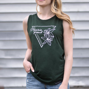 A woman wearing a green sleeveless tank top with a triangular lily flower design on the front.