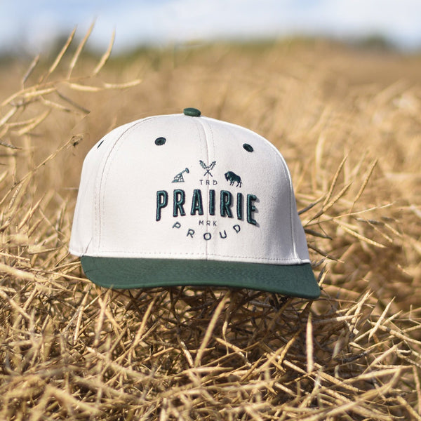 A snapback hat with a green brim and a white crown, with green text that says 'Prairie Proud'.