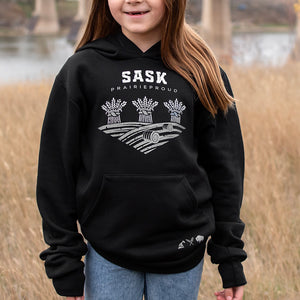 A child wearing a black hoodie with 'SASK Prairie Proud' text and a graphic design on the front.