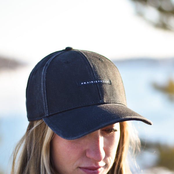 A person wearing a black, distressed baseball cap with the brand name 'PRAIRIE PROUD' visible on the front.
