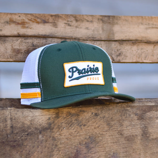 A green, yellow, and white trucker hat with 'Prairie Proud' written on the front.