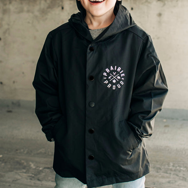 Youth wearing a black button-up jacket with side pockets and left chest embroidery of 'Prairie Proud'.