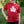 A child wearing a red short-sleeve t-shirt with a white maple leaf graphic that says 'Prairie Proud' in black script, standing outdoors in a grassy area.
